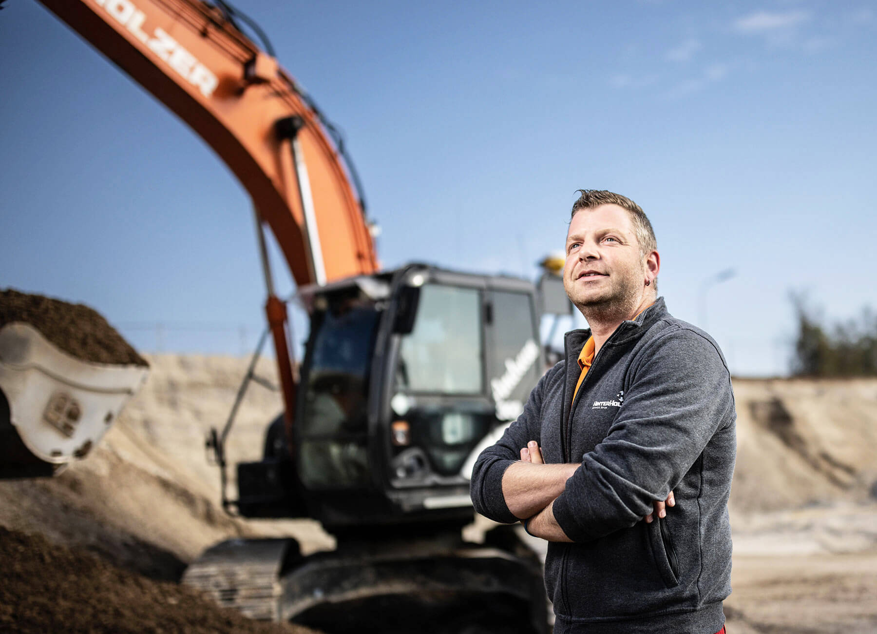 Mitarbeiter von HinterHolzer vor einem Bagger