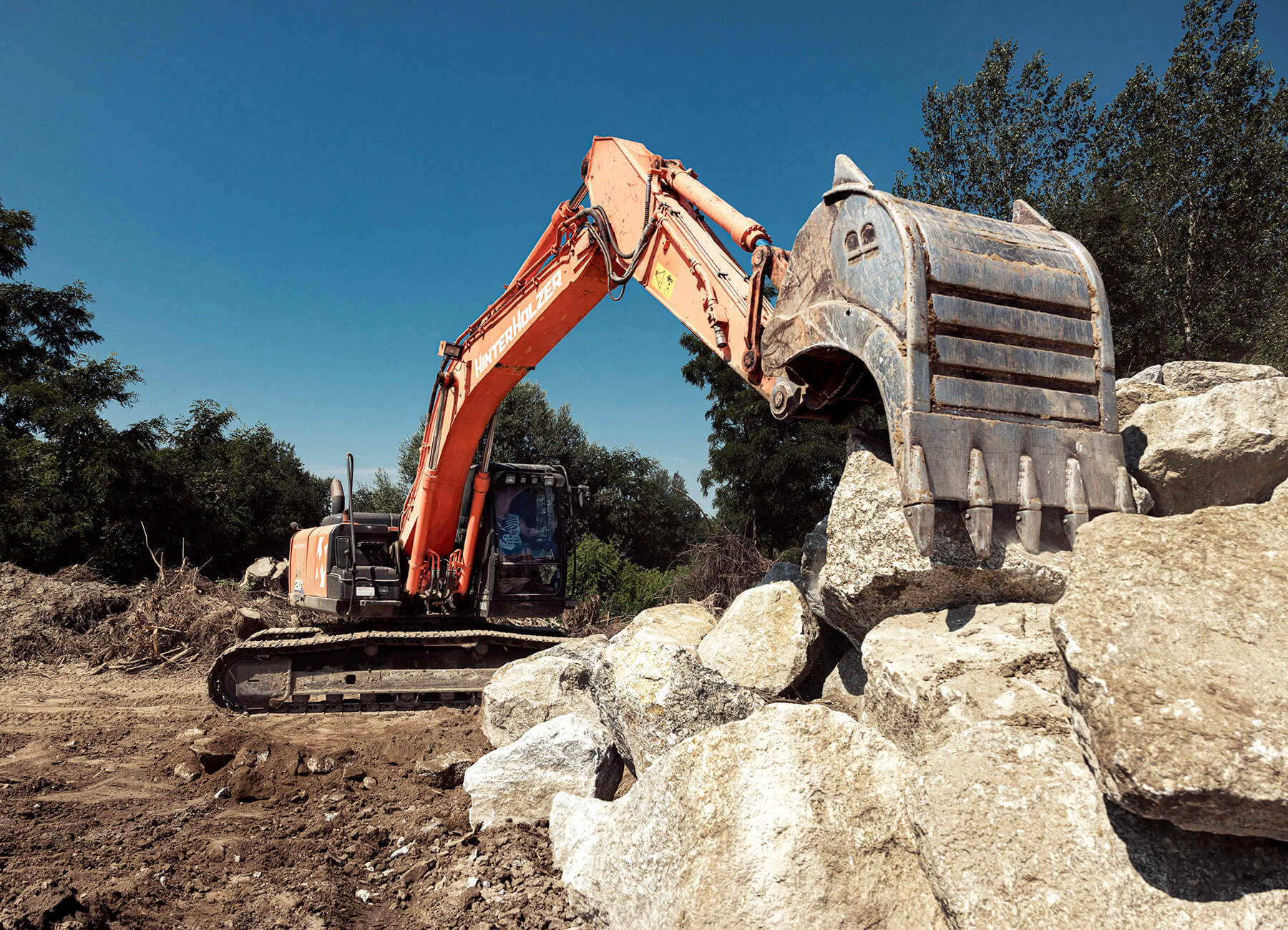 Bagger bei Abbrucharbeiten mit Natursteinen